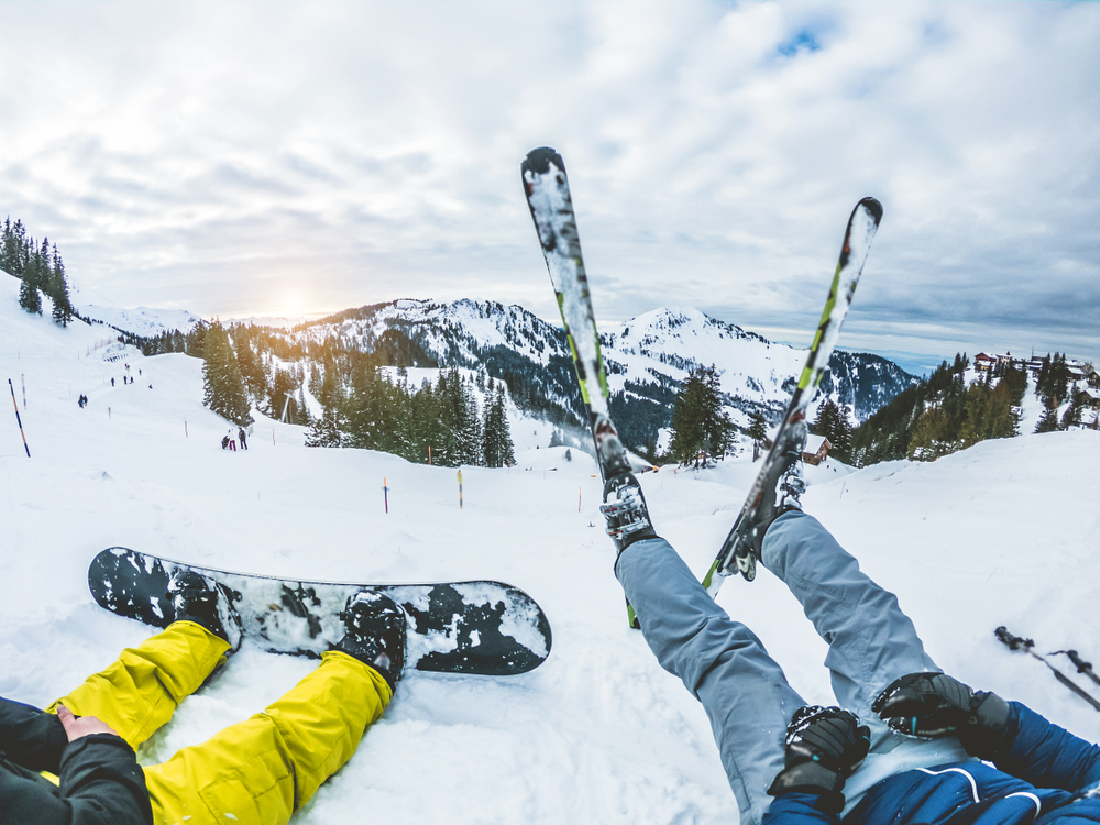 Two,Friends,With,Snowboard,And,Ski,Watching,The,Sunset,On