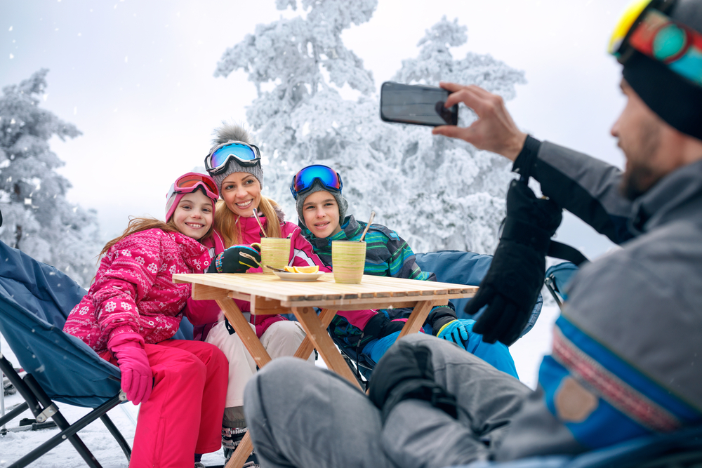Happy,Family,Takes,Tea,Break,During,Skiing,On,The,Mountain