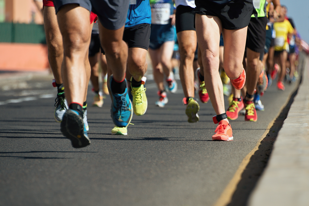 Marathon running in the light of evening,running on city road detail on legs